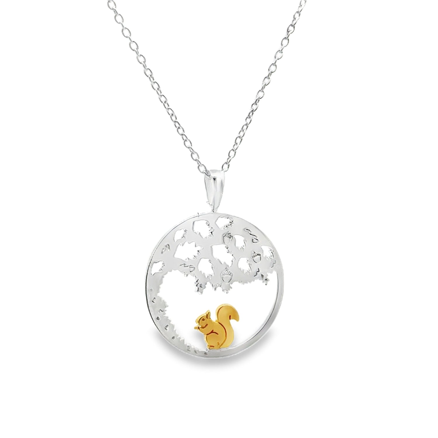 A circular pendant with cut out design to mimic an oak tree inside, with a gold plated squirrel sat underneath the tree. The design hangs on a sterling silver adjustable chain.