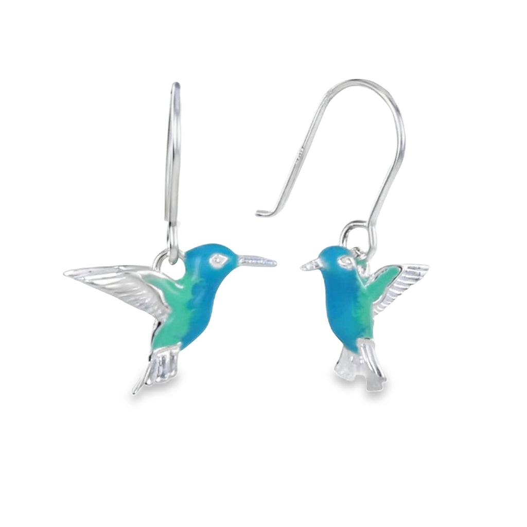 Hummingbird-shaped earrings, in sterling silver with blue and green enamel detail, hanging on silver hooks.