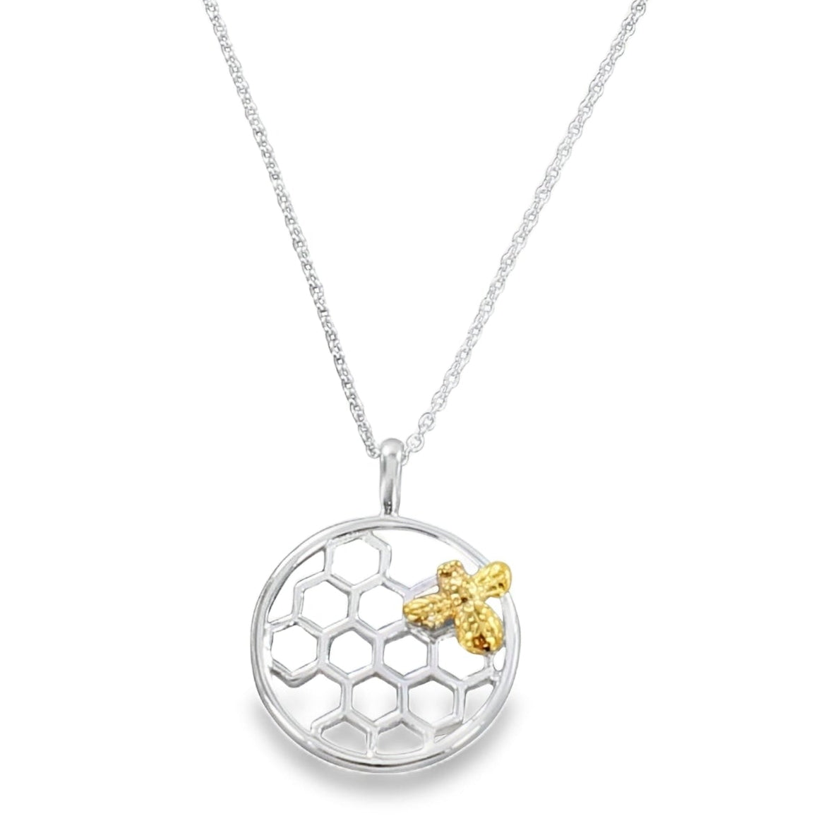 A silver honeycomb pendant with an 18ct gold plate bee sitting on top. The pendant is circular in shape and sits on an adjustable sterling silver chain. Shown on a white background.