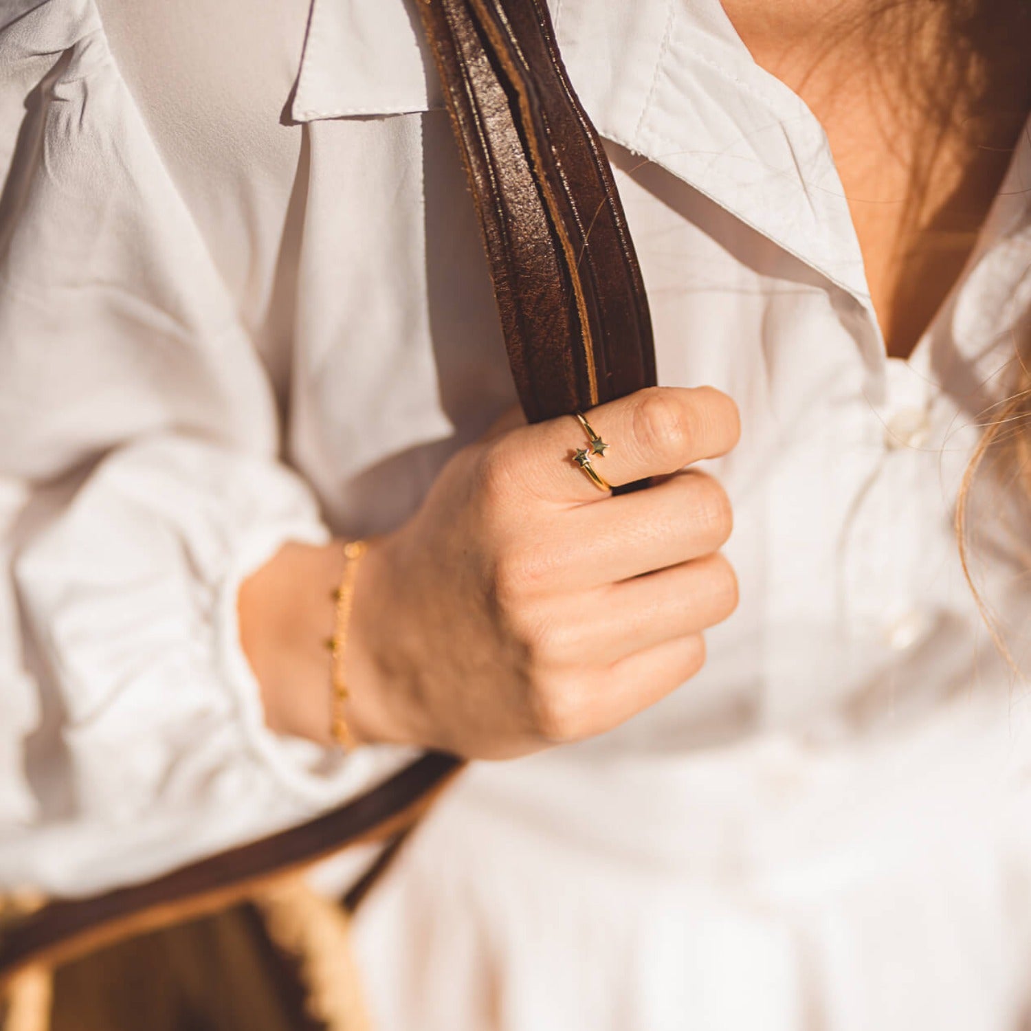 A gold plated adjustable ring, with two stars at either end of the band that wrap around a women's finger.