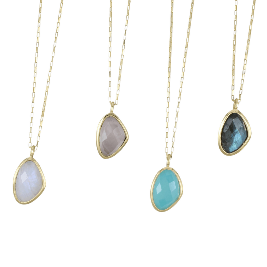 Four necklaces, each with a semi precious stone set in gold plating and hanging on gold box chains. Stones shown are moonstone, rose quartz, aqua chalcedony and labradorite.