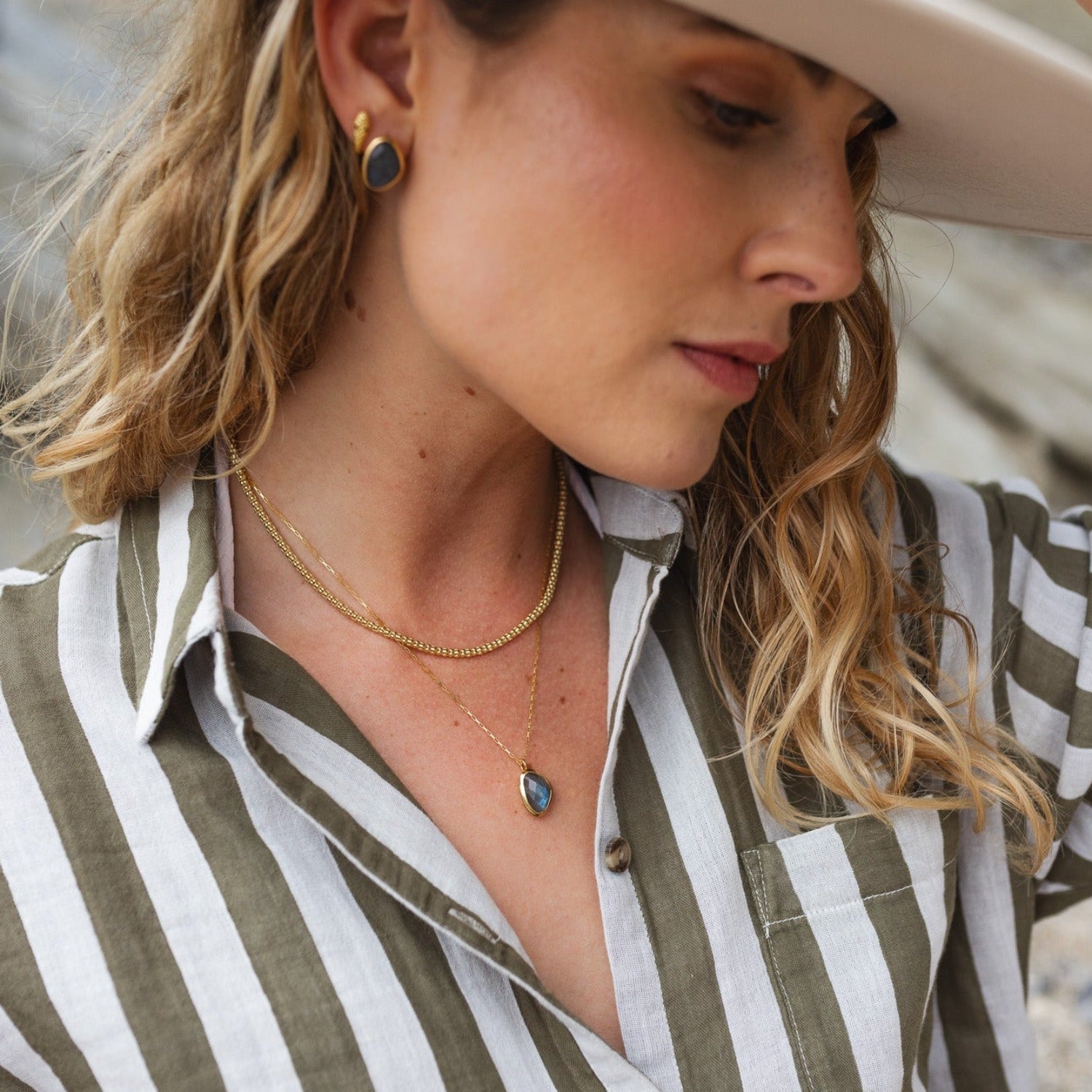 Silver and gold plate bobble chain necklace worn on a model and layered with a labradorite stone necklace.