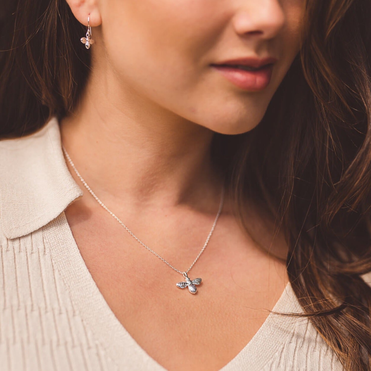 A Sterling Silver Bumble Bee Necklace shown on an adjustable silver chain, worn on a model.