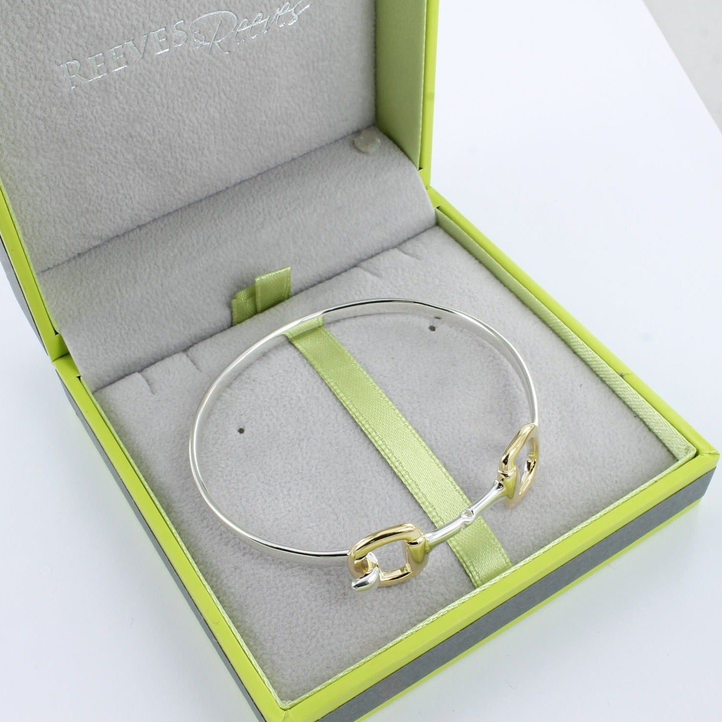 A chunky Snaffle Cuff Bracelet with gold vermeil on the snaffle bits, shown in a Reeves & Reeves branded gift box.