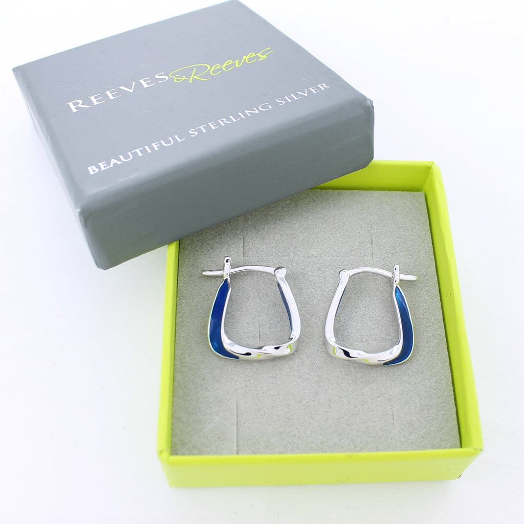 Silver hoop earrings with blue enamel detail on one side of each hoop. The hoops are shown in grey and green Reeves & Reeves branded gift box.