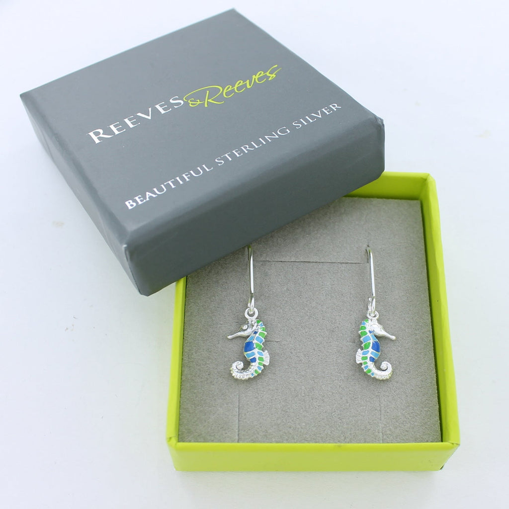 Silver Seahorse Earrings with blue and green enamel detail on silver hooks, shown in a Reeves & Reeves branded gift box.