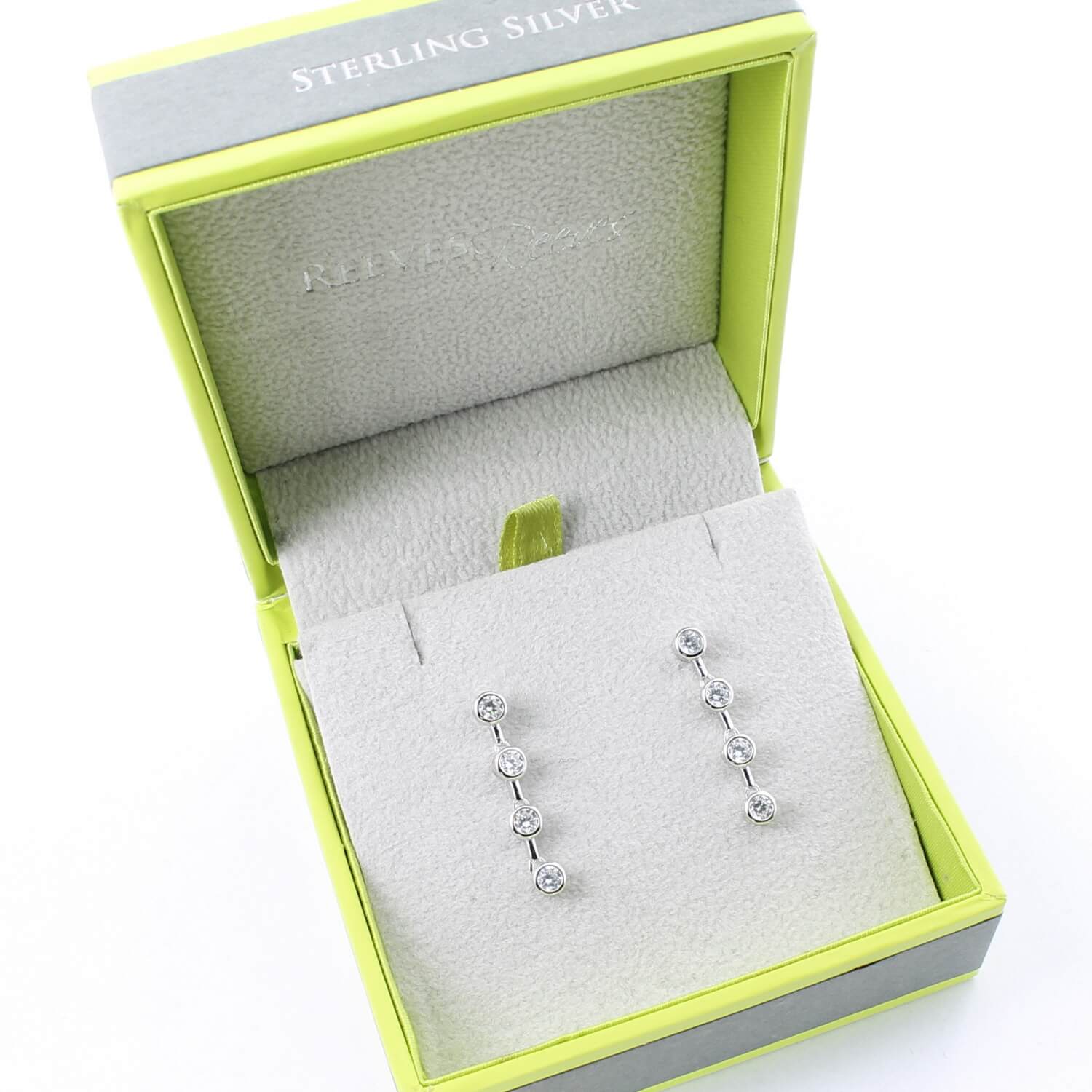 A pair of sterling silver drop earrings, with cubic zirconia stones set in a vertical line. Shown in a Reeves & Reeves gift box.