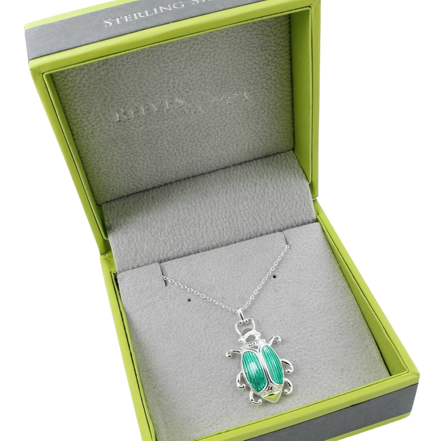 A sterling silver queen beetle pendant with emerald green detail on its back, hung on a silver adjustable chain and shown in a Reeves & Reeves gift box.