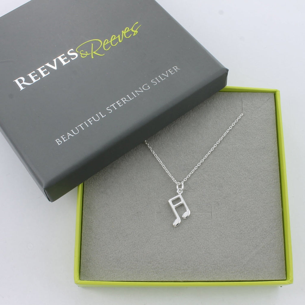 A Sterling Silver Music Note Necklace on a silver chain, shown in a Reeves & Reeves grey and green branded gift box.