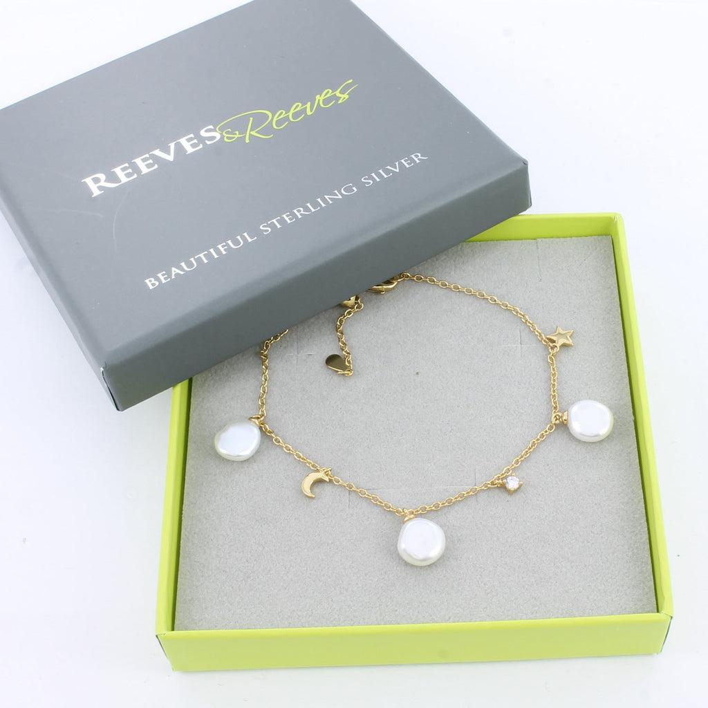 Gold plated chain bracelet with white freshwater pearls and moon and star charms along the chain. Shown in a Reeves & Reeves box.