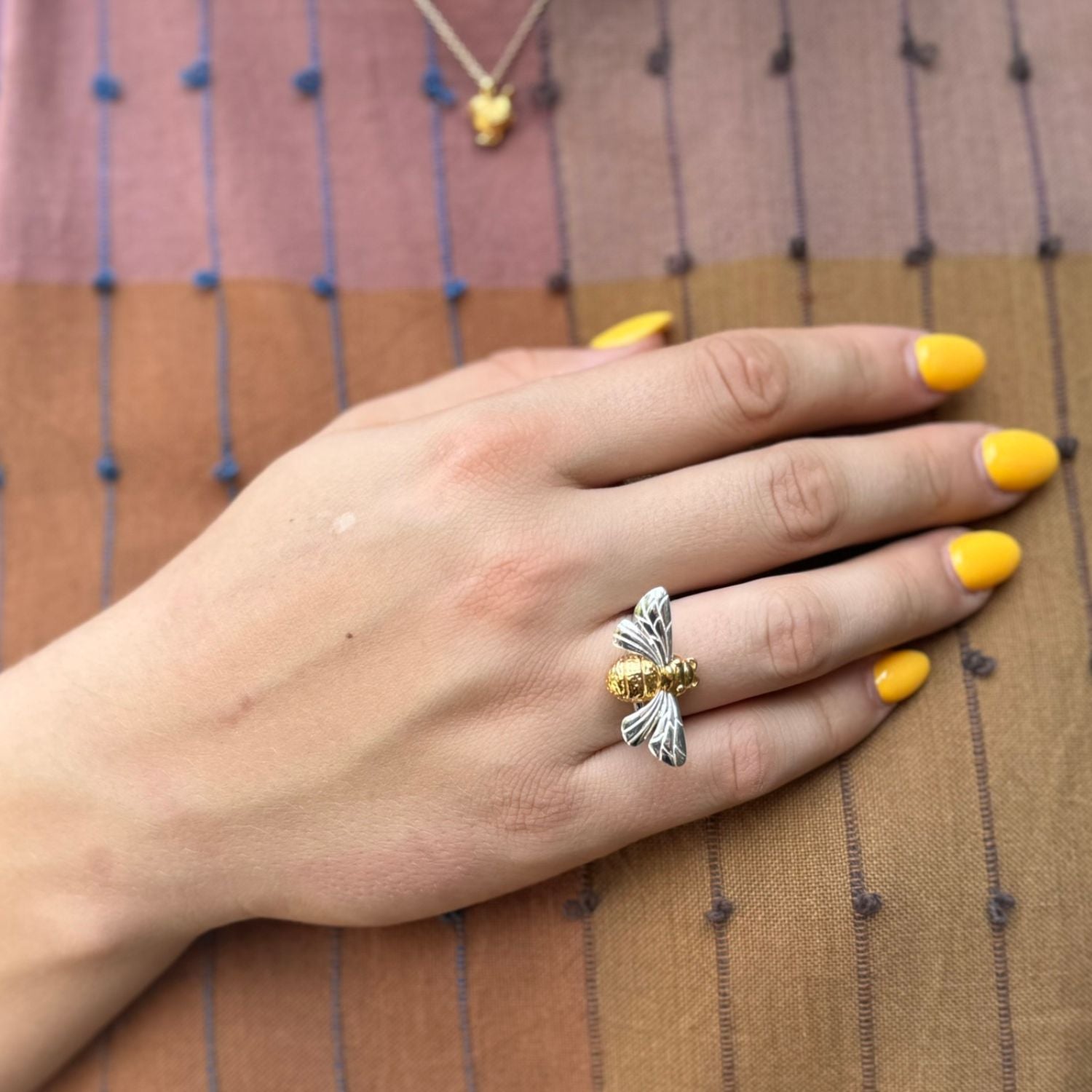 A sterling silver and 18ct gold plate queen bee ring, on an adjustable band and worn on a ladies hand.