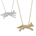 Gold and silver fox pendants on chains against a white background