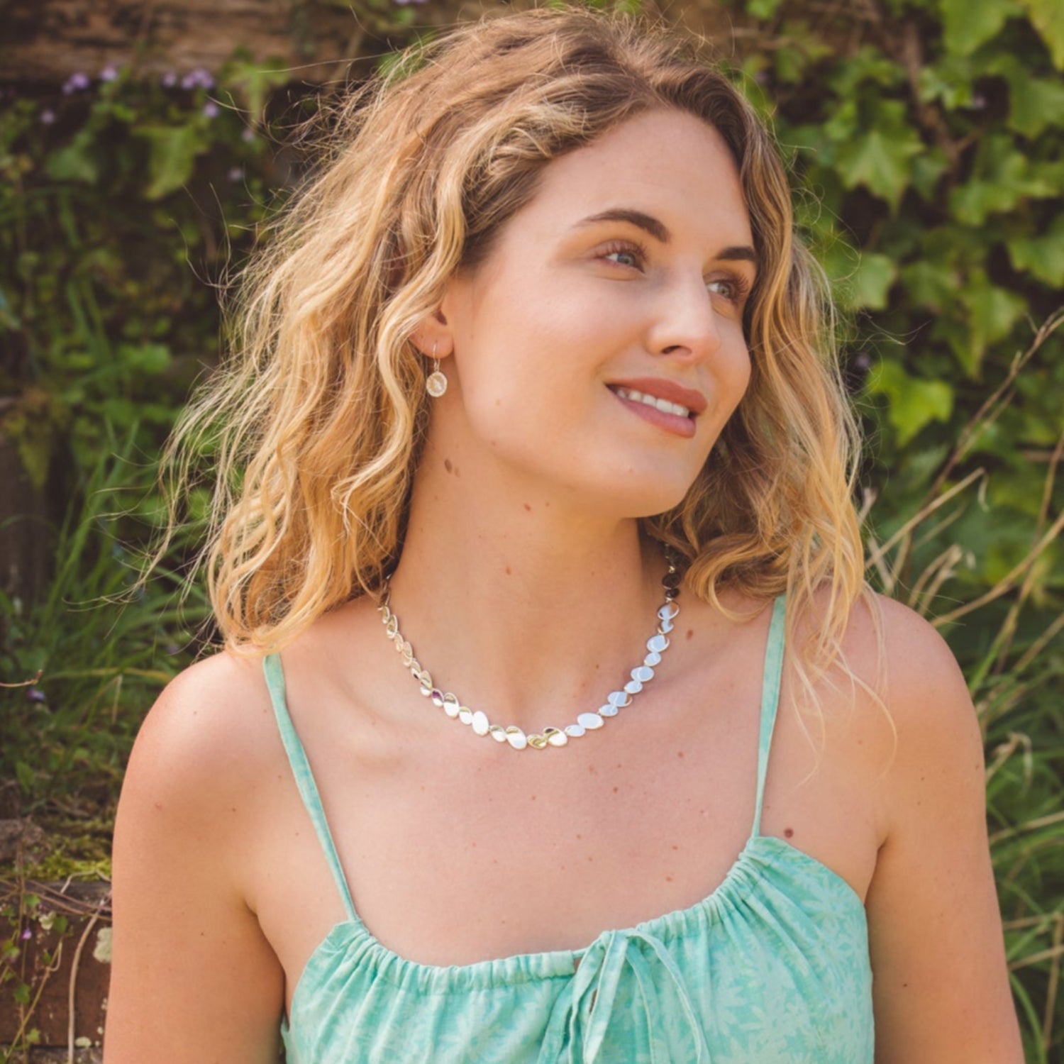 A sterling silver shiny nugget necklace, comprises of high shine oval discs, worn on a model.