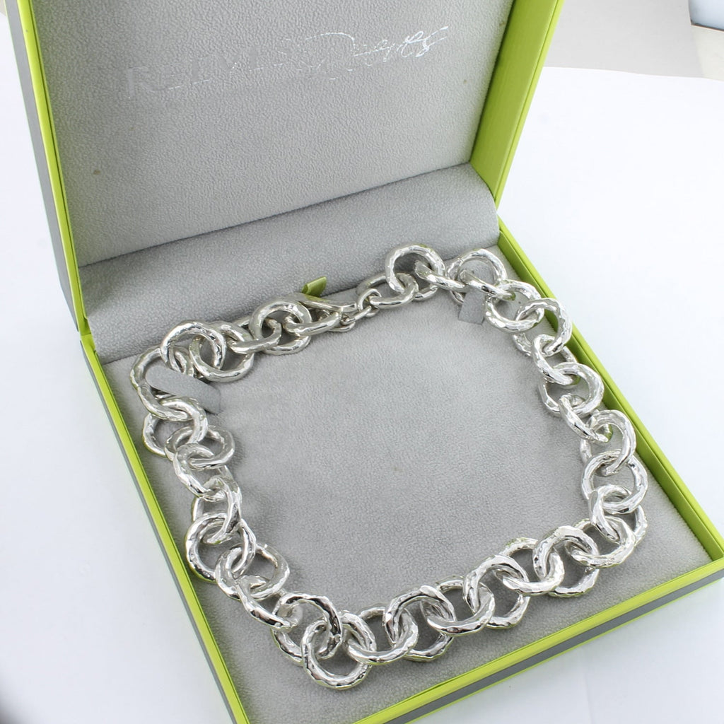 A sterling silver statement necklace, comprised of interlinking hammered circles. Shown in a Reeves & Reeves grey and green gift box.