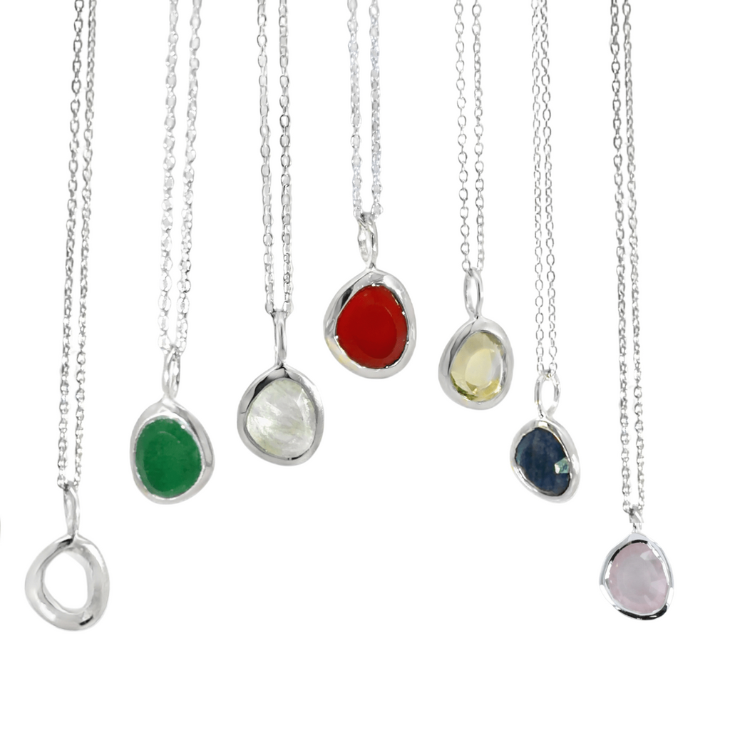 A collection of semi precious stones in varying birth months, set in silver bezels and hanging from silver adjustable chains.
