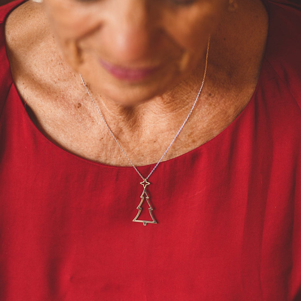 Sterling Silver Christmas Tree pendant with a gold plated star on the top. Hung on a silver adjustable chain and worn on a model.