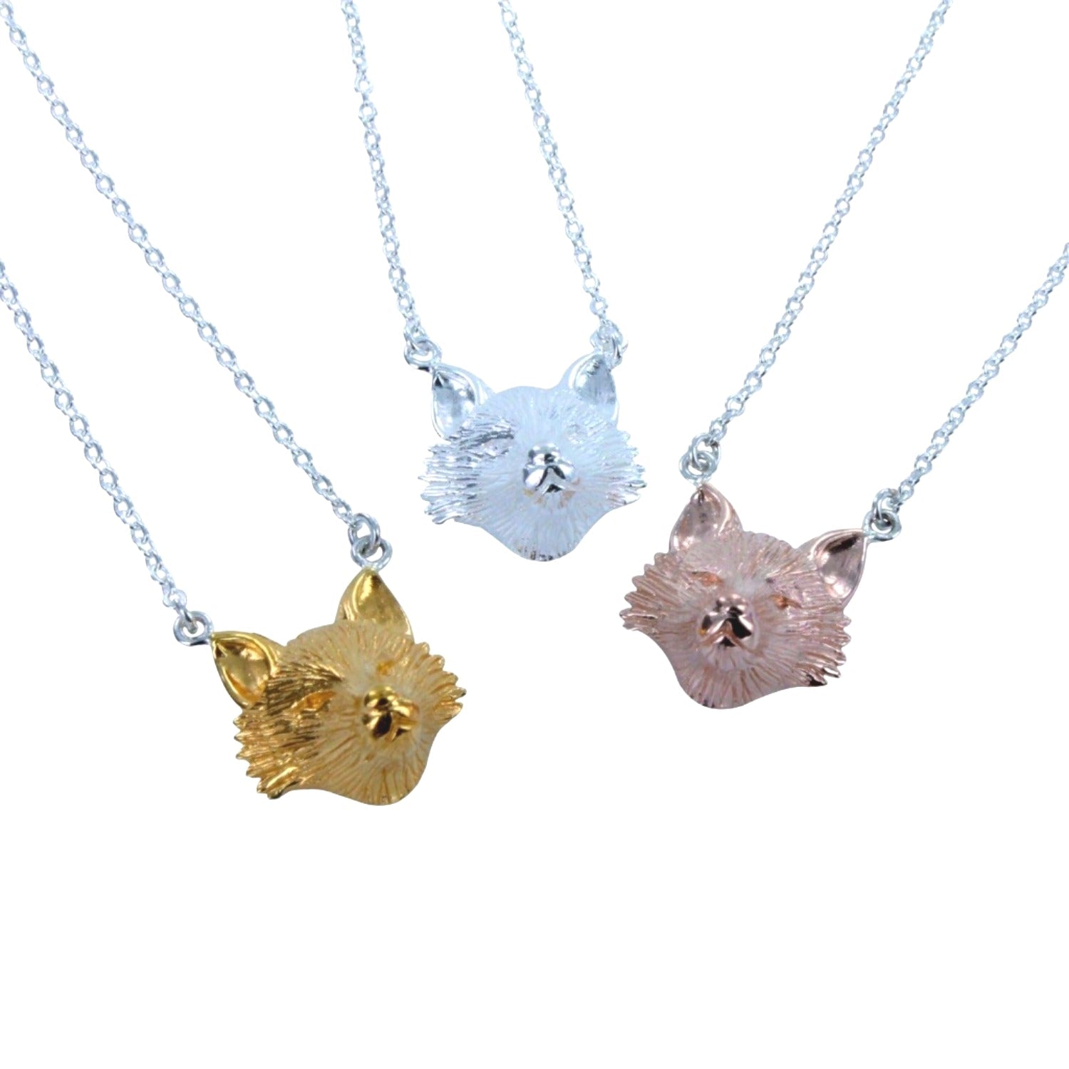 Three fox head pendants, one gold plate, one silver and one rose gold, hanging on sterling silver chains. 