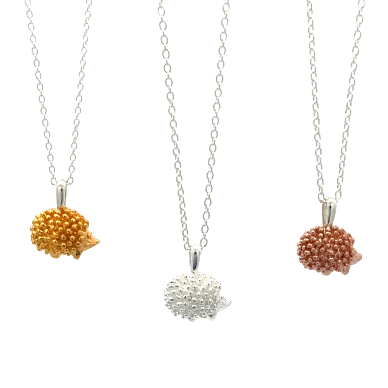 Three Hedgehog Pendants, one gold plate, one silver and one rose gold, hanging on adjustable silver chains, shown on a white background.