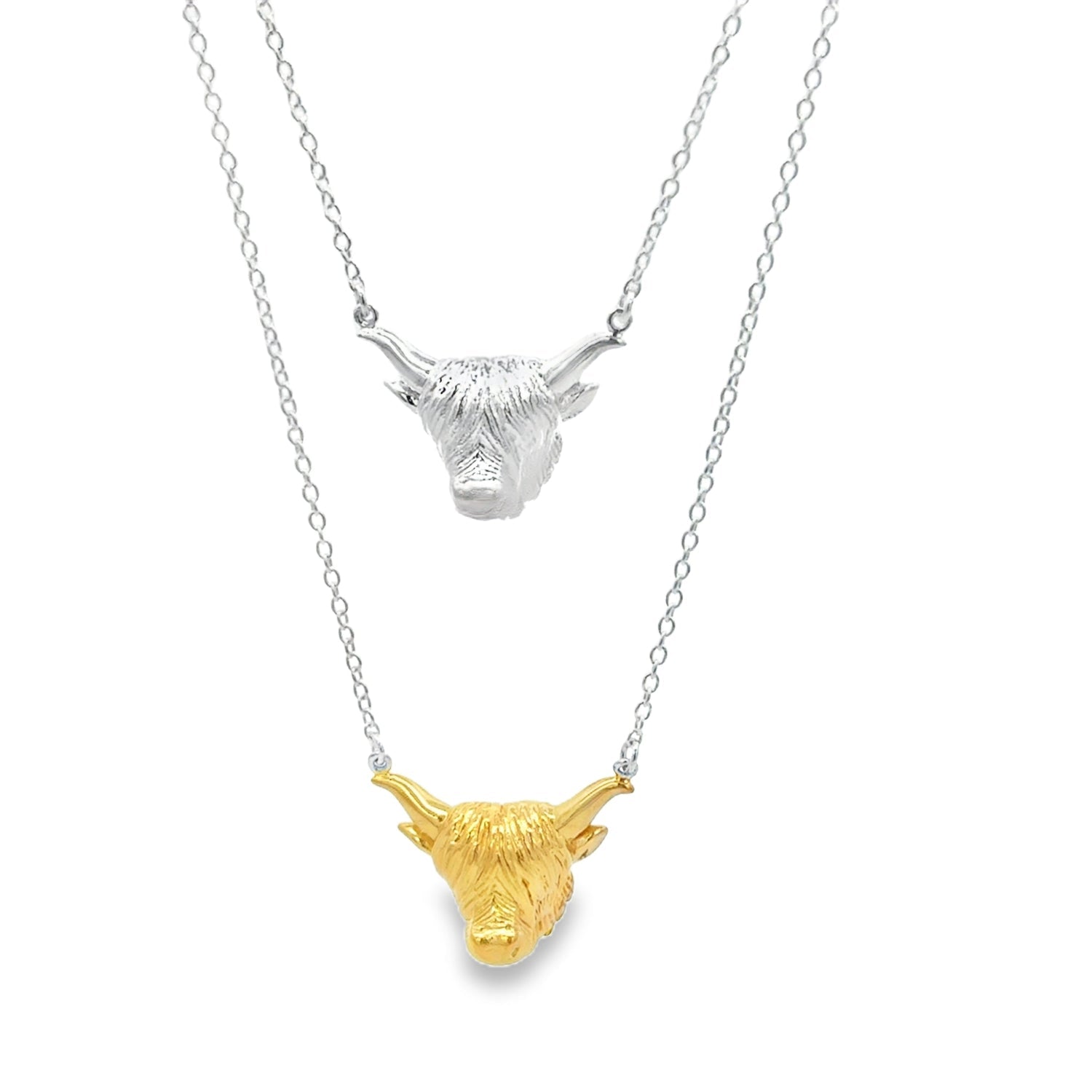 Two Highland Cow Head Necklaces, one silver, one with gold plate finish, hanging on sterling silver adjustable chains. Nature inspired gifts for her.