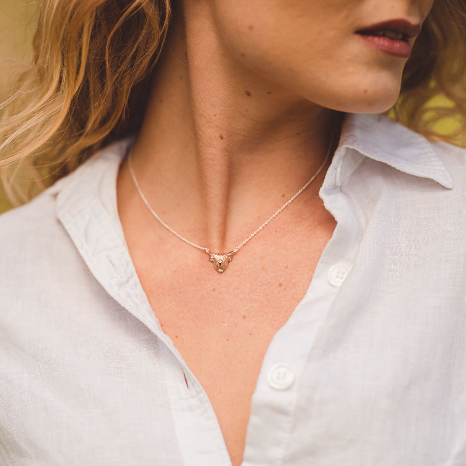 Sterling Silver Highland Cow Head Necklace, on a sterling silver chain worn by a model. Nature inspired gifts for her.