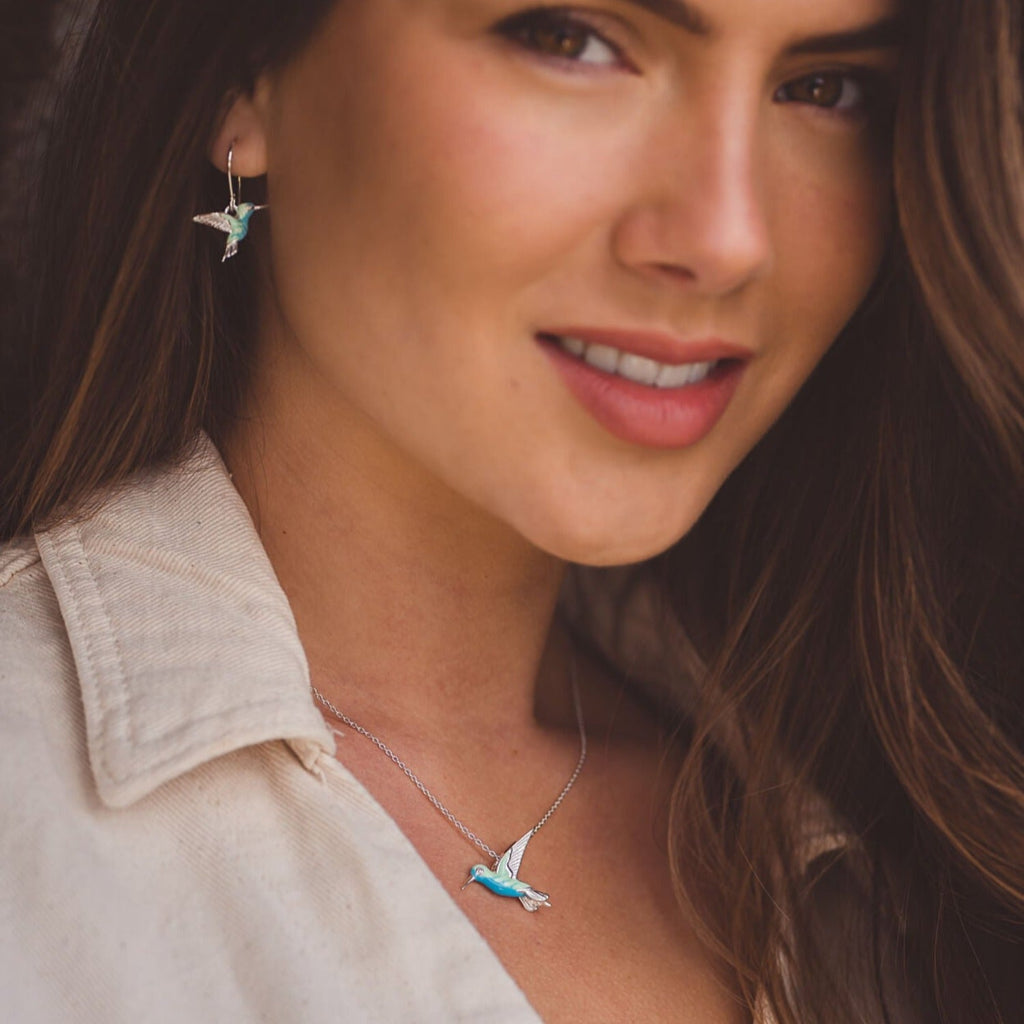 Sterling Silver and Enamel Hummingbird Necklace on a silver chain with matching drop earrings, worn on a model. Nature inspired gift for her.