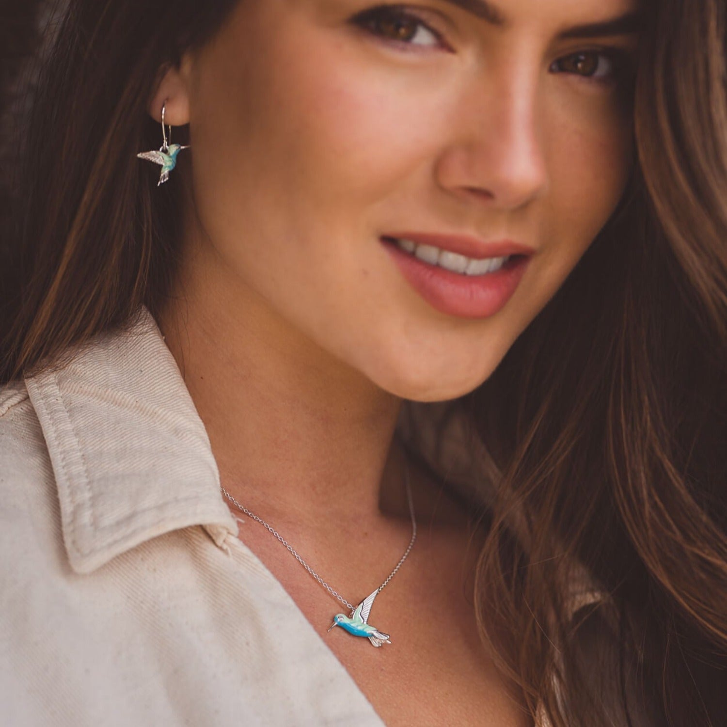 Sterling Silver and Enamel Hummingbird Necklace on a silver chain with matching drop earrings, worn on a model. Nature inspired gift for her.