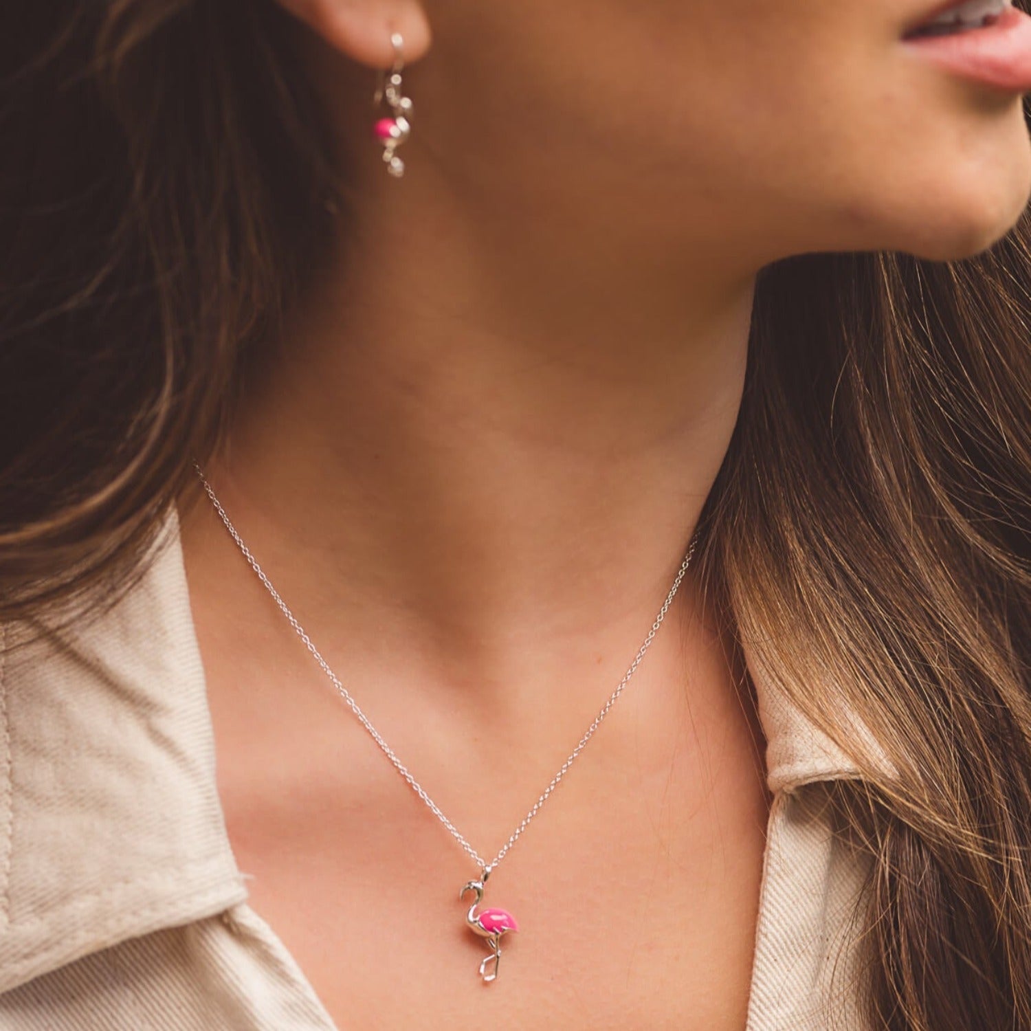 Sterling Silver Flamingo Necklace with hot pink enamel detail and worn on a model on an adjustable silver chain.