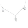Silver chain necklace with starfish, conch shell, and scallop shell hanging as separate charms along the chain.