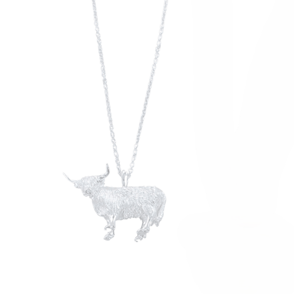Silver Highland Cow pendant necklace hanging on a silver chain.
