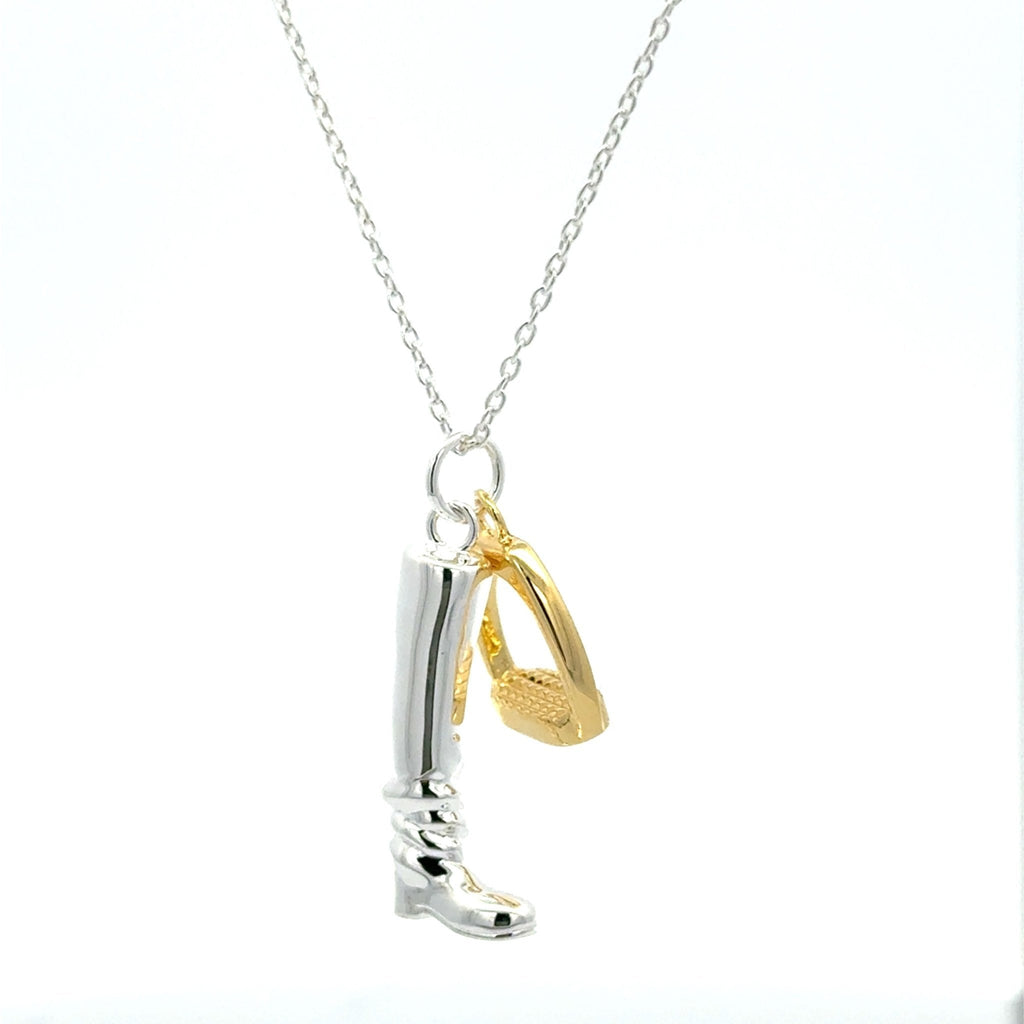 A sterling silver riding boot charm with a gold plated stirrup charm hanging side by side, both hung on a silver adjustable chain.