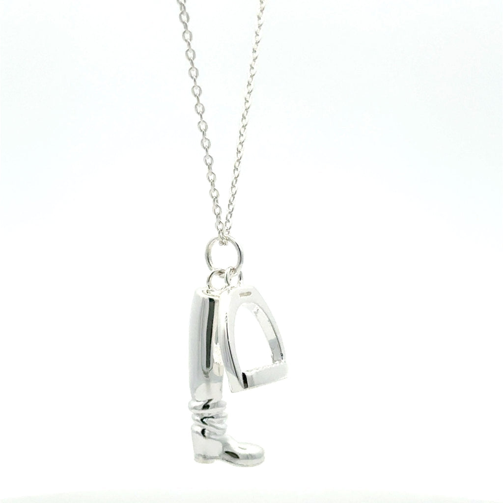 A sterling silver boot and stirrup charm hanging from a silver adjustable chain.