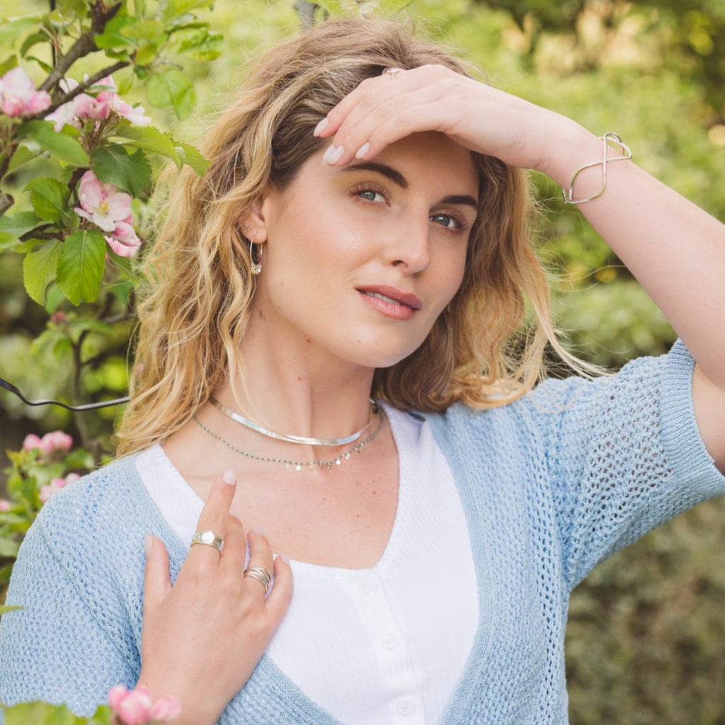 A Silver thick snake chain worn on a model, layered with an enamel turquoise dotty necklace.