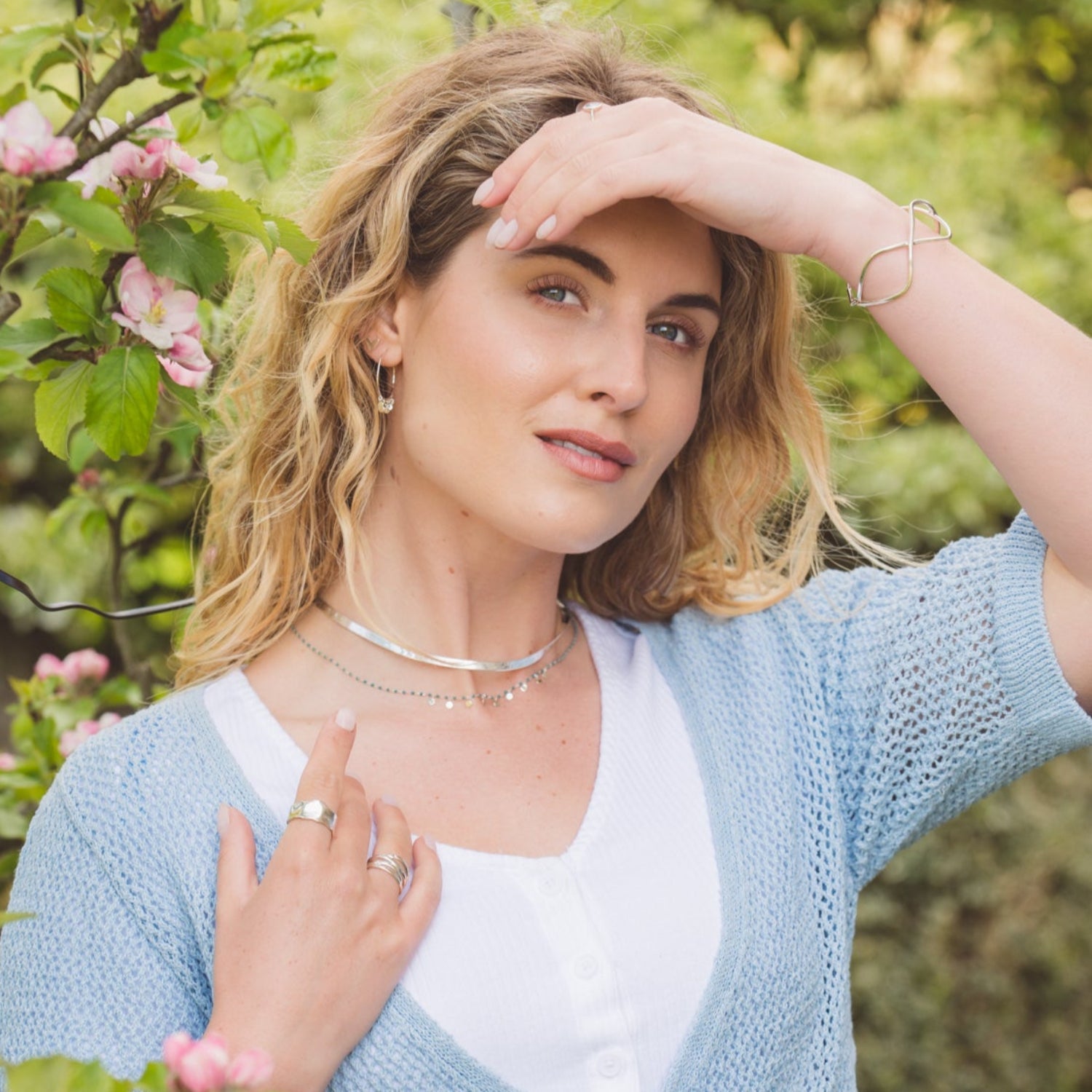 A Silver thick snake chain worn on a model, layered with an enamel turquoise dotty necklace.
