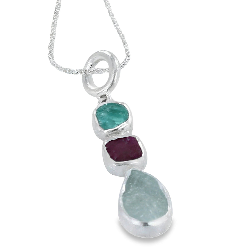 Sterling silver pendant with three rough stones, one aqua, one ruby and one apatite in a vertical design, hung on a rope style chain.
