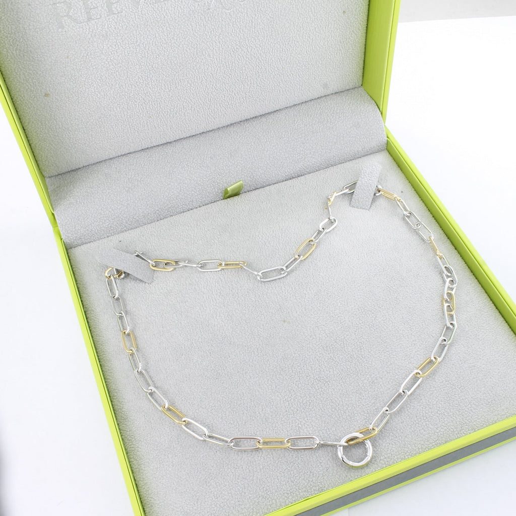 A sterling silver paperclip style chain, with 18ct gold plating on every fourth link. The necklace is finished with a circular clasp and is shown in a Reeves & Reeves grey and green gift box.