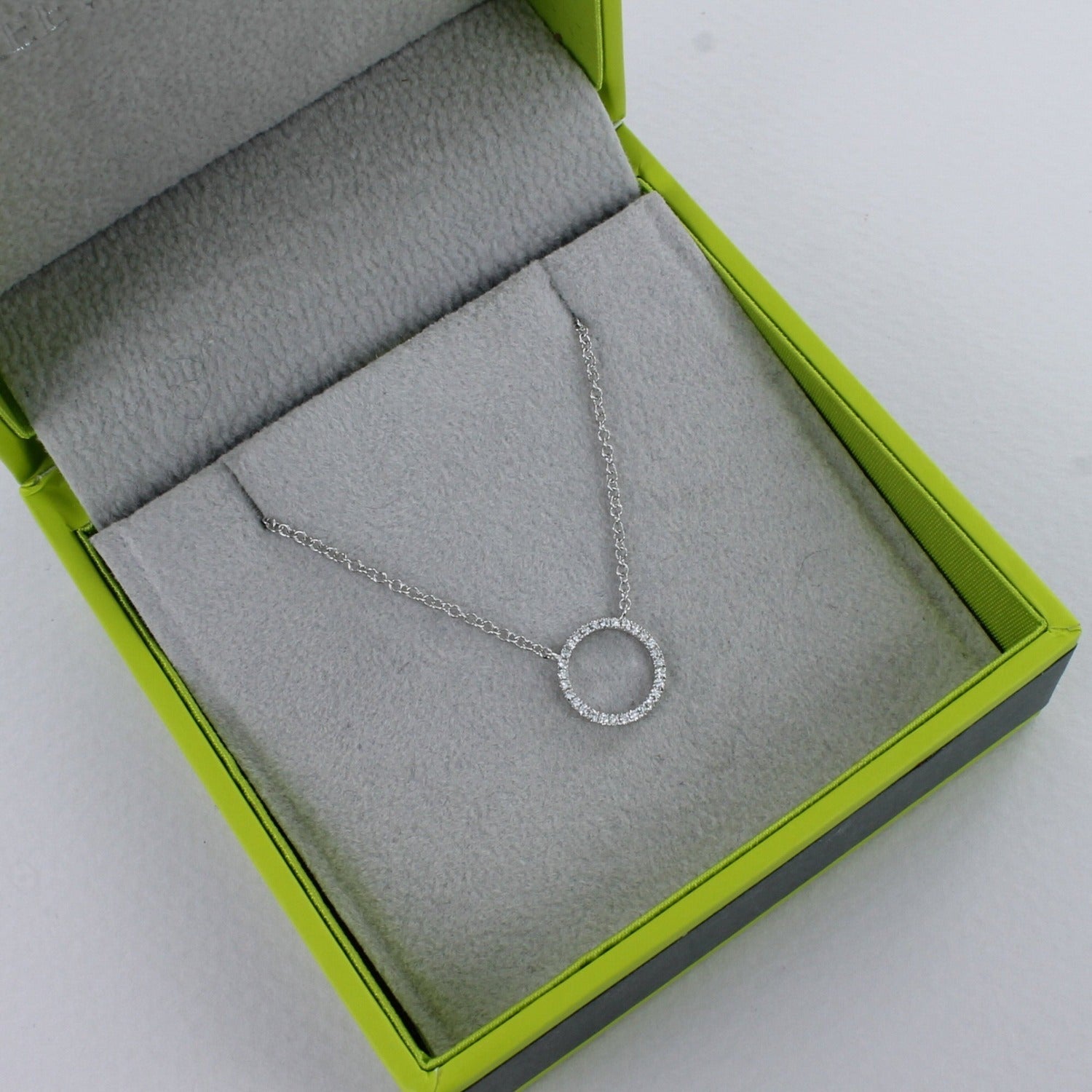 A solid 14k white gold ring necklace, encrusted with diamonds and shown in a Reeves & Reeves gift box.