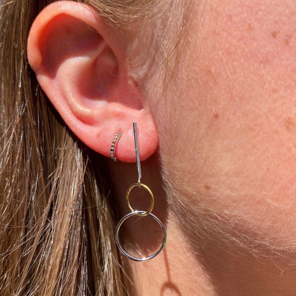 A drop style earring, with two interlinking circles hanging from the bottom, one sterling silver and one 18ct gold plate.