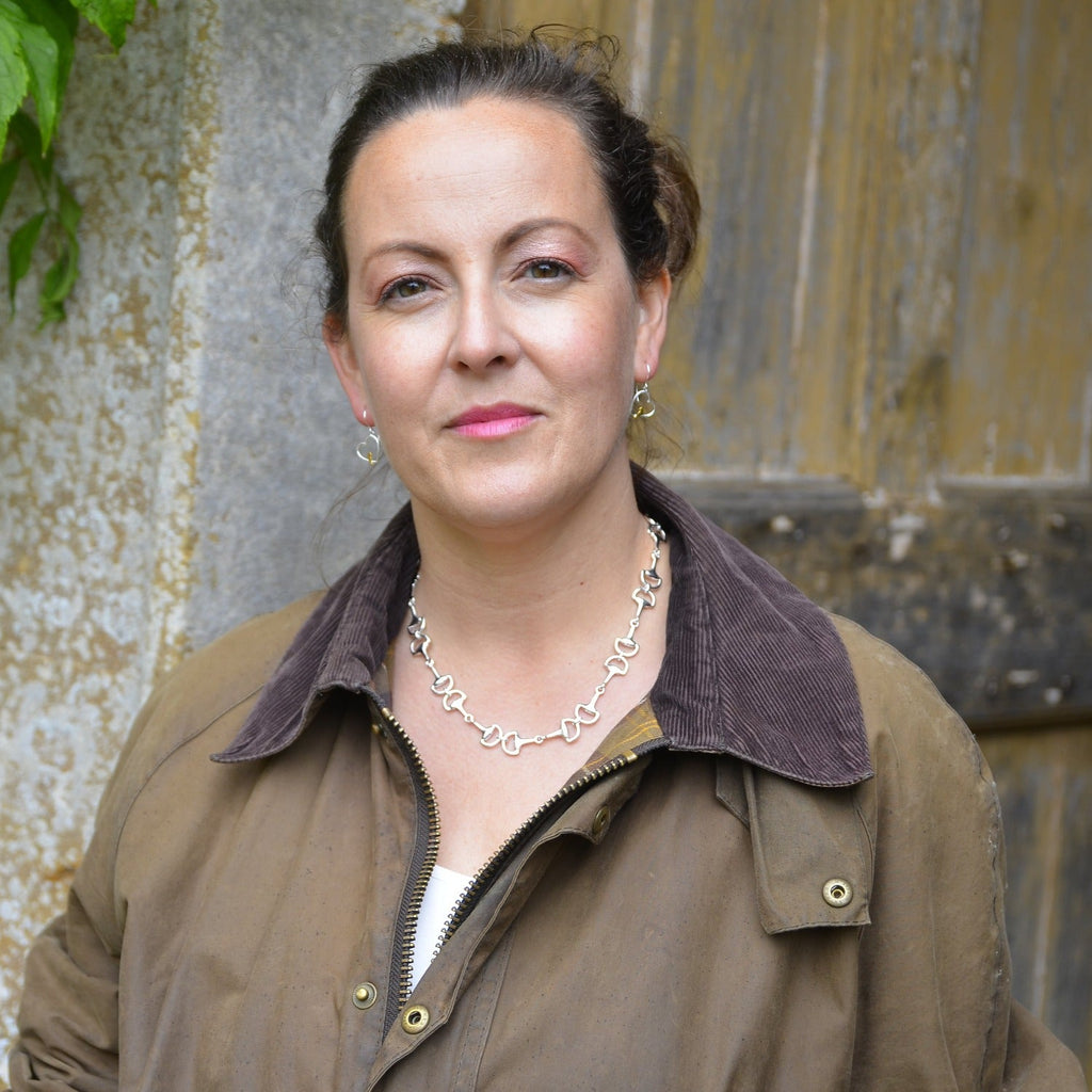 A Sterling Silver continuous snaffle necklace, shown on a model wearing a Barbour jacket.