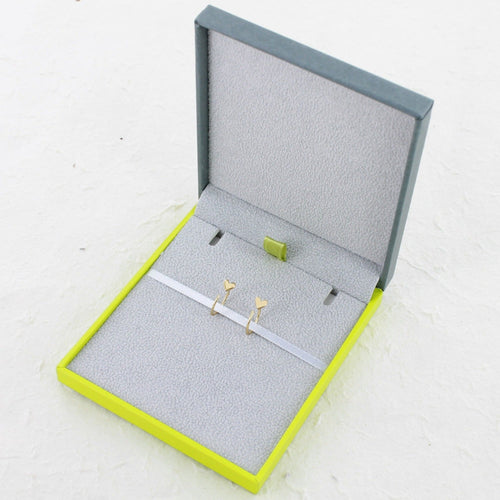 A pair of crescent hoop earrings in silver and gold plate, with hearts at the front of the hoop. Shown in a Reeves & Reeves gift box.