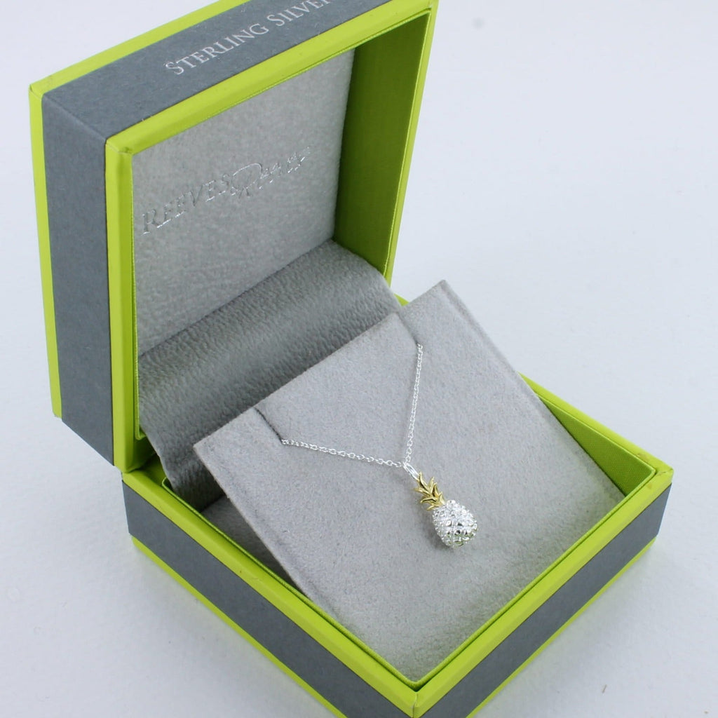 A Sterling Silver and gold plated Pineapple Necklace on a silver chain and shown in a Reeves & Reeves grey and green gift box.