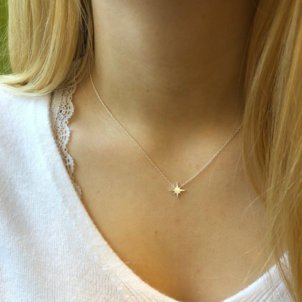 Sterling Silver eight point star sat centrally on a fine silver chain and worn on a model.
