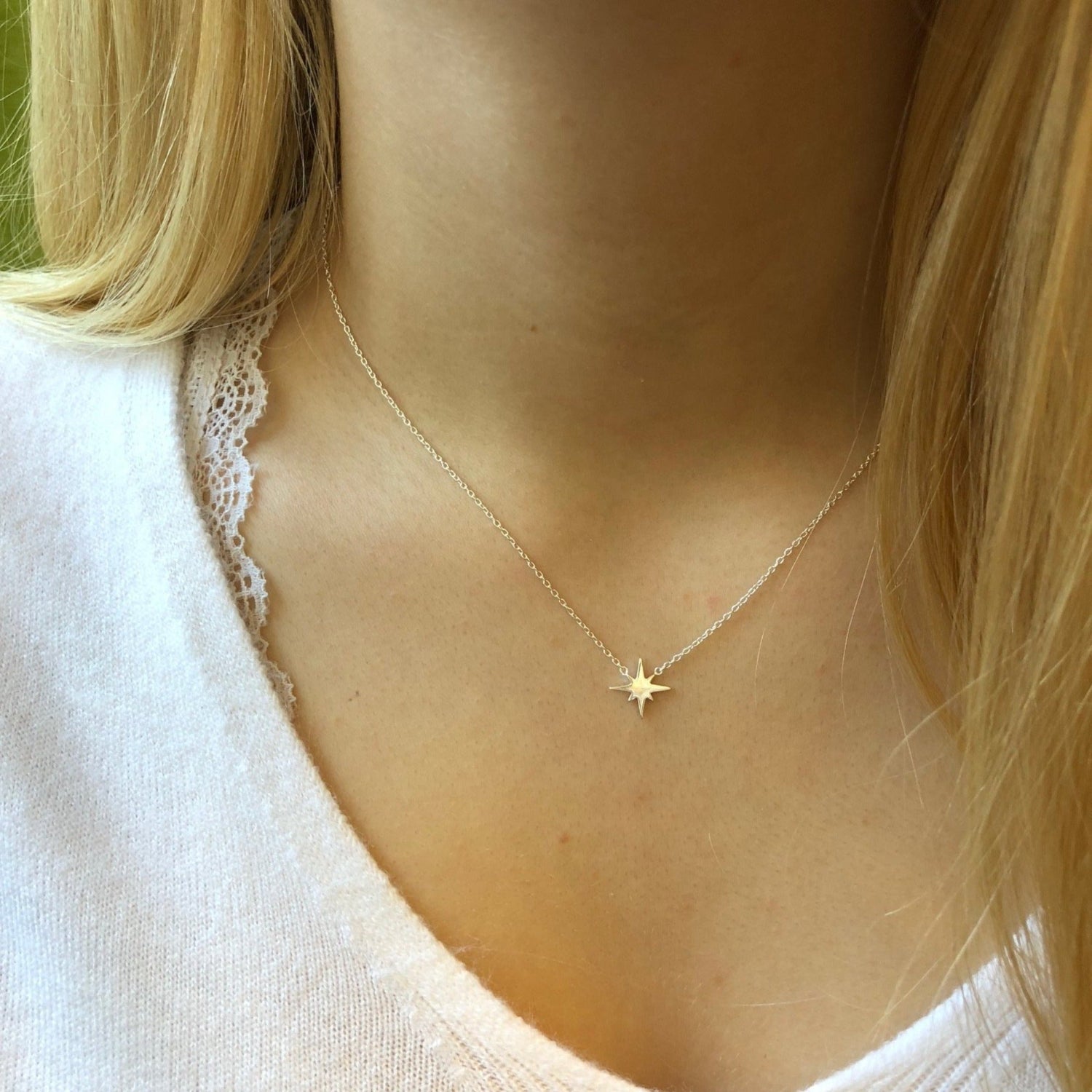 Sterling Silver eight point star sat centrally on a fine silver chain and worn on a model.
