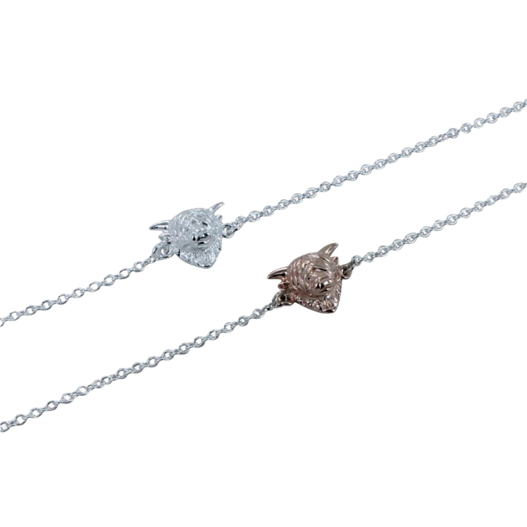 Two silver chain bracelets in silver, onr with a silver highland cow head and one with a rose gold head.