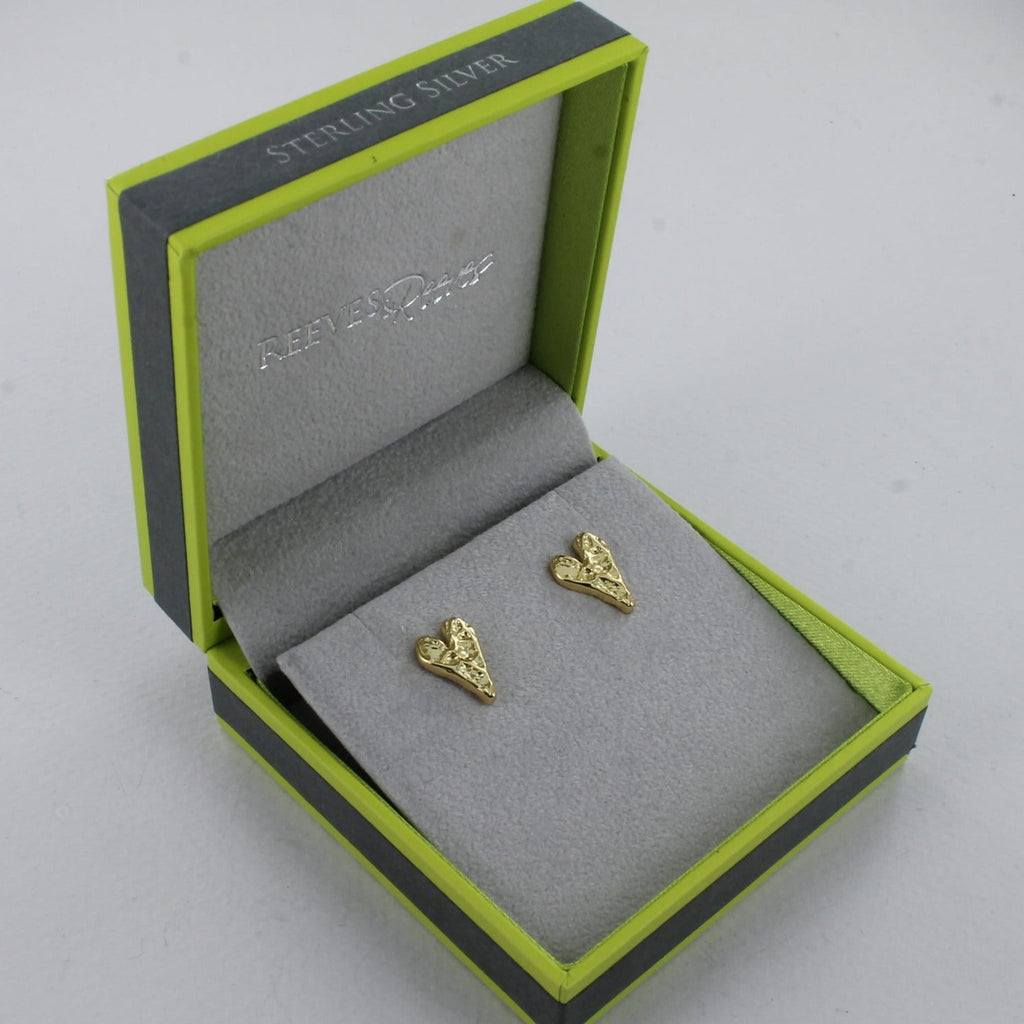 A pair of sterling silver and gold plated heart studs with a textured finish, shown in a Reeves & Reeves gift box.