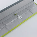 Sterling Silver paperclip style chain with a t bar clasp and a textured heart hanging from the clasp.
