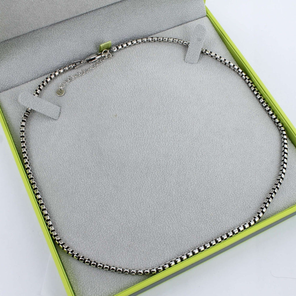 A sterling silver men's box chain, shown in a grey and green Reeves & Reeves gift box.