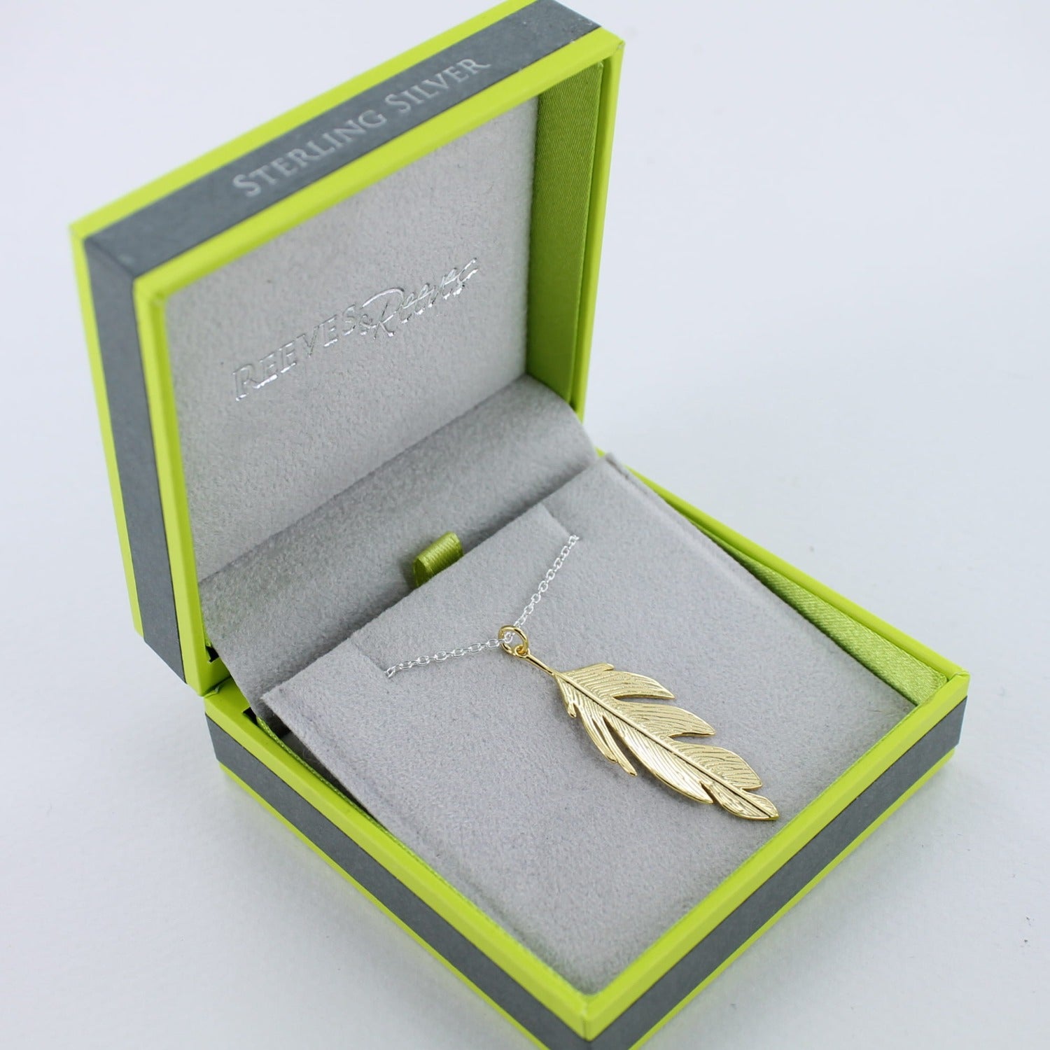 Feather drop necklace in gold plate, in a Reeves & Reeves grey and green branded gift box.