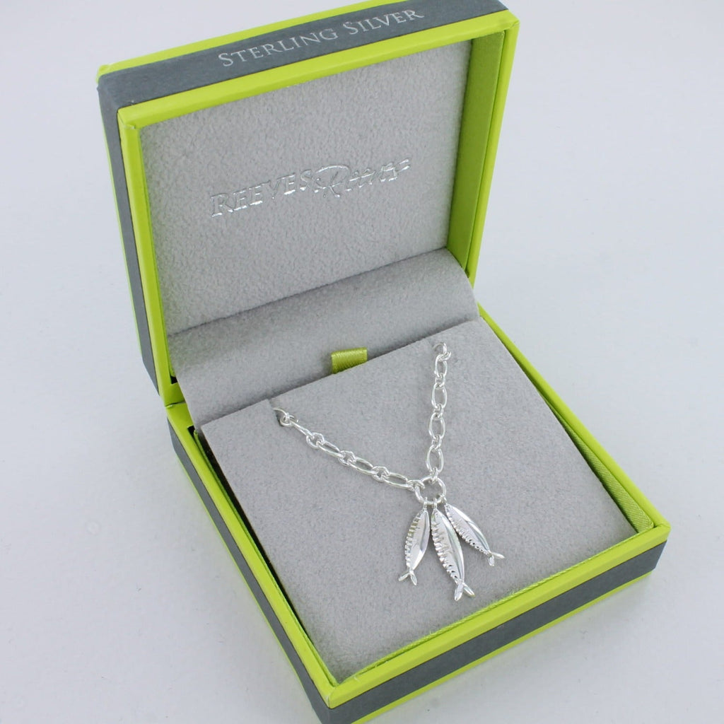 A Sterling Silver chain necklace with three silver fish dangling from the centre. Shown in a Reeves & Reeves grey and green branded gift box.