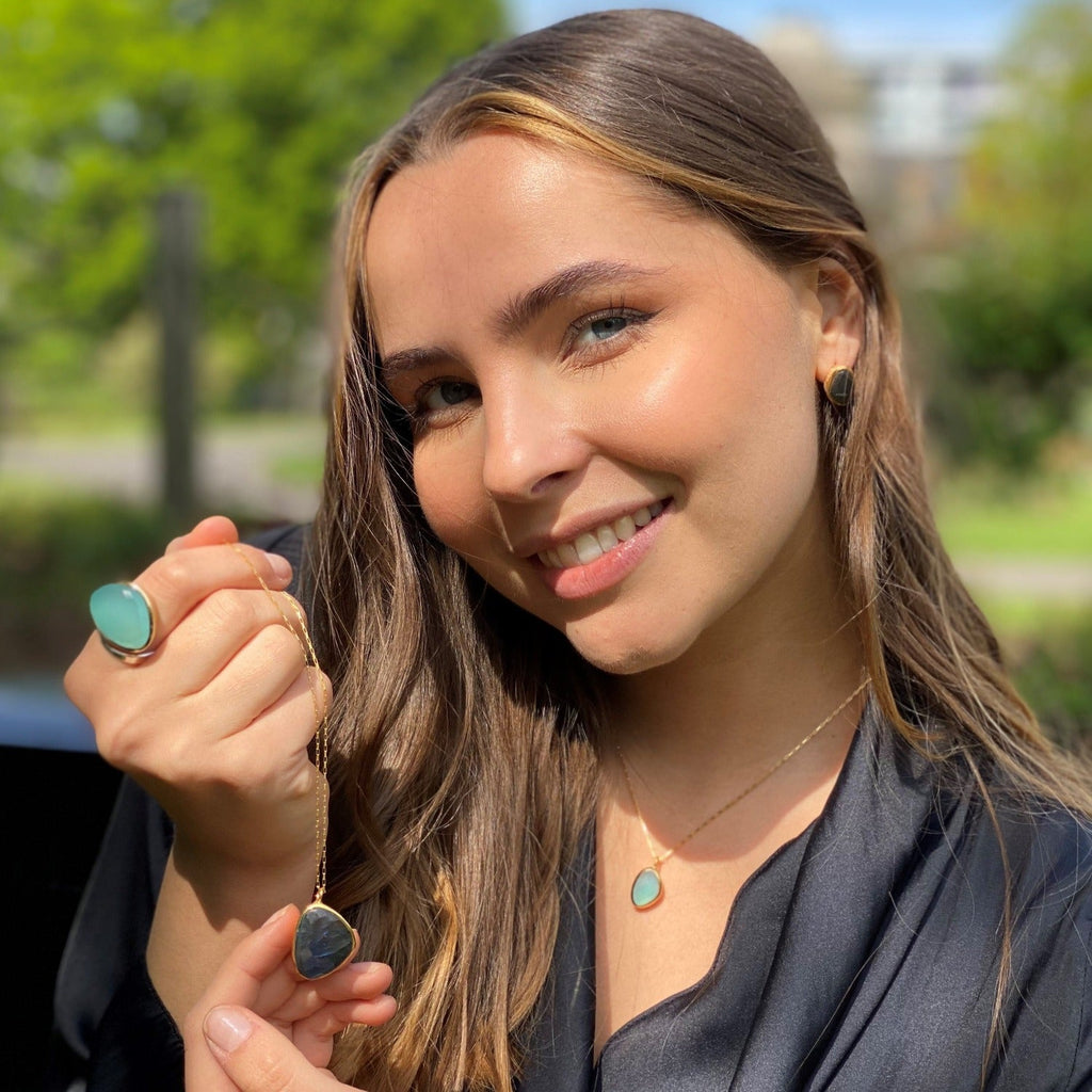 Semi precious stones of labradorite and aqua chalcedony, in rings, necklaces and earrings, worn on a model.