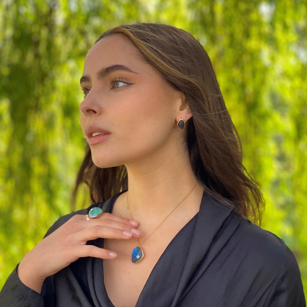 Large Labradorite Stone Necklace, set in gold plate and hanging on a gold plated box chain. Worn on a model with matching stud earrings.